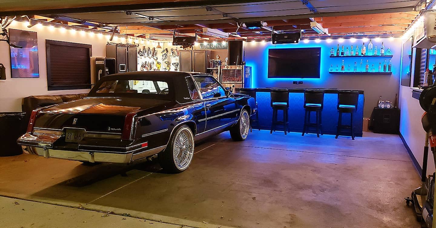 large garage with wet bar led lighting wall mounted tv cement floor 